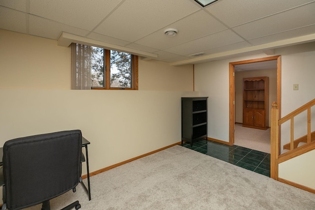 office space featuring baseboards, a paneled ceiling, dark tile patterned floors, and dark carpet