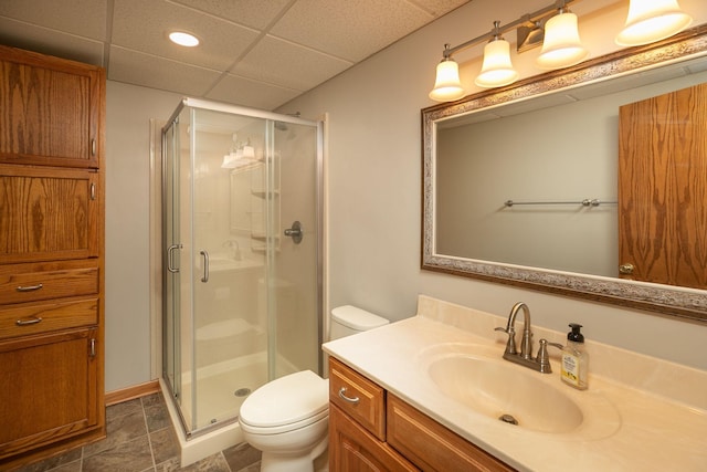 full bathroom with a paneled ceiling, vanity, toilet, and a shower stall