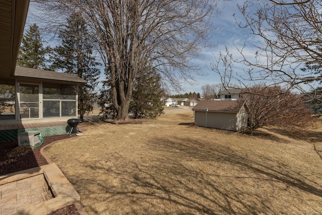 view of yard featuring a storage unit, an outdoor structure, and a sunroom