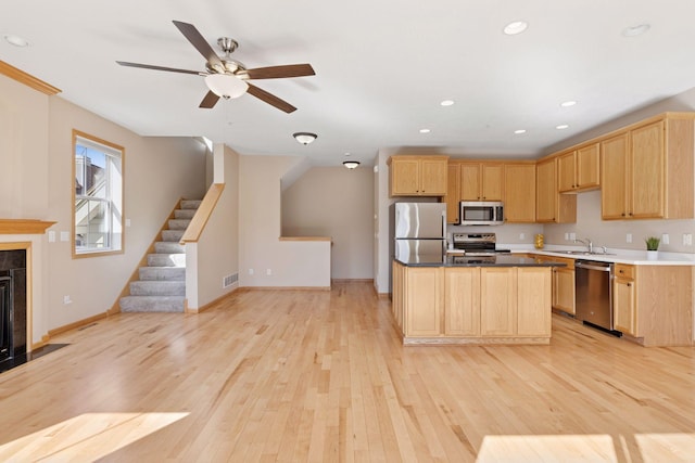 kitchen with light wood-style flooring, light brown cabinets, and appliances with stainless steel finishes