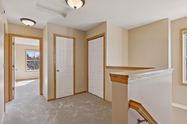 corridor with carpet flooring and baseboards