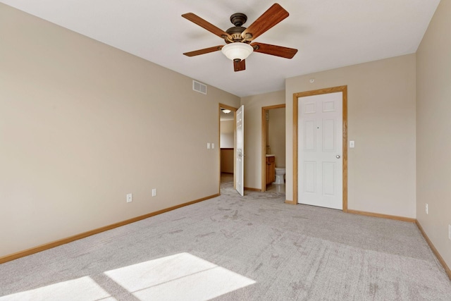 unfurnished bedroom featuring visible vents, carpet flooring, connected bathroom, and baseboards