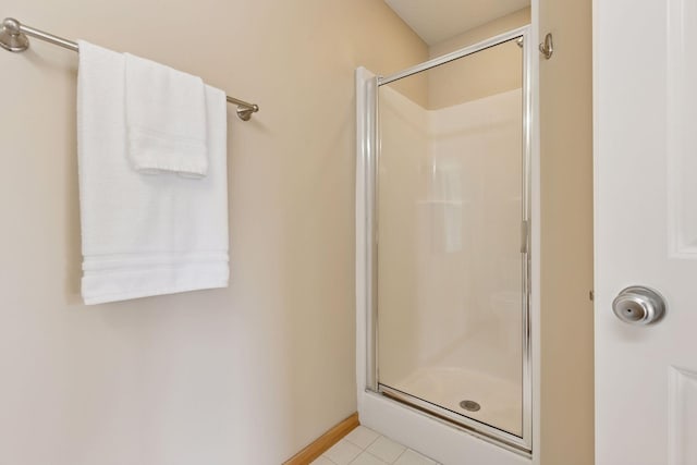 bathroom featuring baseboards, a stall shower, and tile patterned flooring