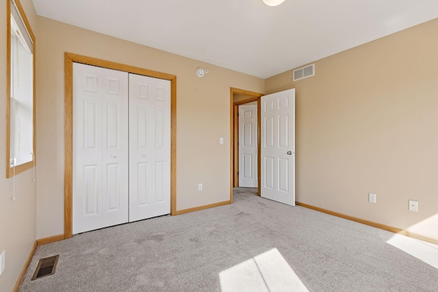 unfurnished bedroom with a closet, visible vents, baseboards, and carpet floors