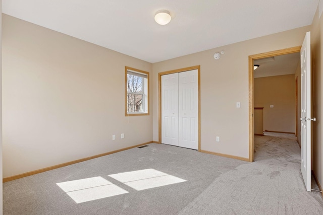 unfurnished bedroom with visible vents, carpet, baseboards, and a closet