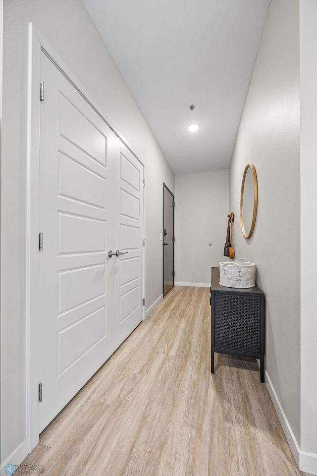 corridor featuring baseboards and light wood-style floors