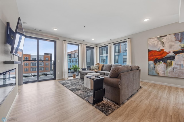 living room with recessed lighting, baseboards, and wood finished floors