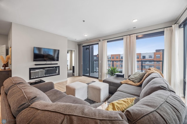 living room with recessed lighting, visible vents, baseboards, and wood finished floors