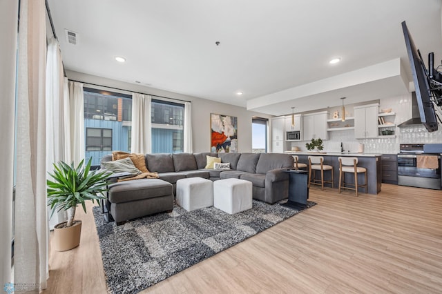 living room featuring recessed lighting, visible vents, and light wood finished floors