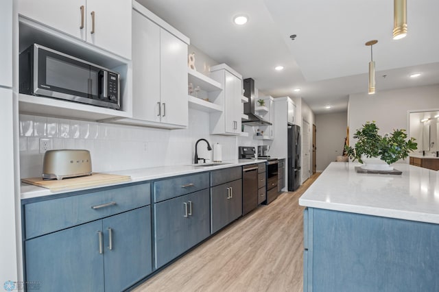 kitchen featuring wall chimney range hood, light wood-style flooring, stainless steel appliances, white cabinetry, and open shelves