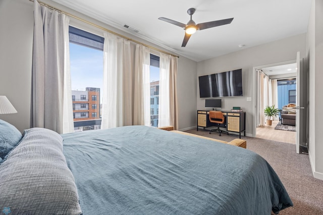 carpeted bedroom featuring visible vents, baseboards, and ceiling fan