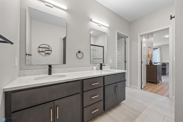 full bath featuring a shower stall, double vanity, and a sink