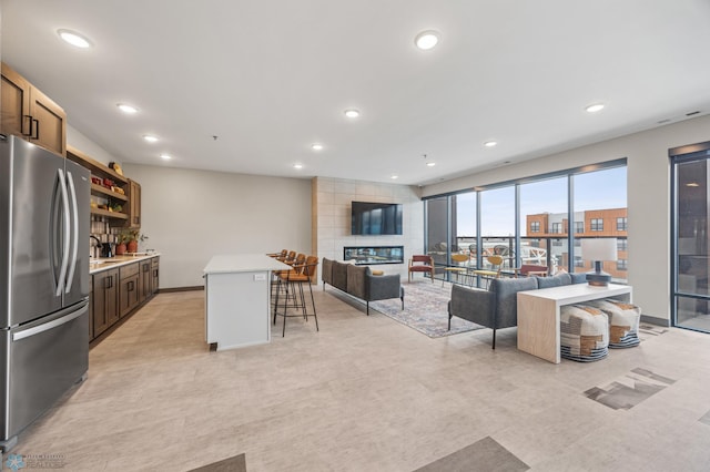 living area with a fireplace, bar, recessed lighting, and light floors