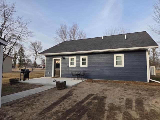 446 Pacific Ave, Hancock, MN 56244 - back of house featuring cooling unit, roof with shingles, and a patio area
