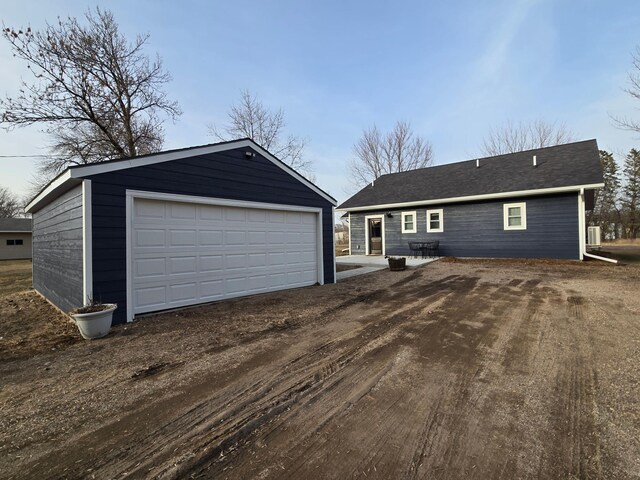 446 Pacific Ave, Hancock, MN 56244 - view of front of home with central air condition unit, a detached garage, and an outdoor structure