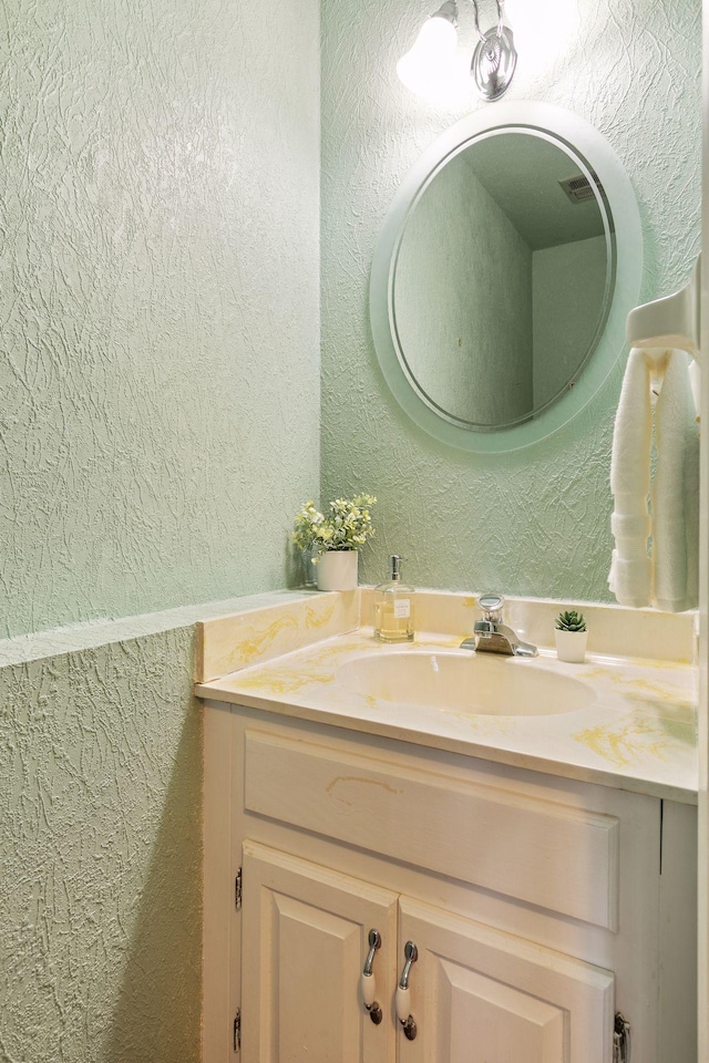 bathroom with vanity and a textured wall