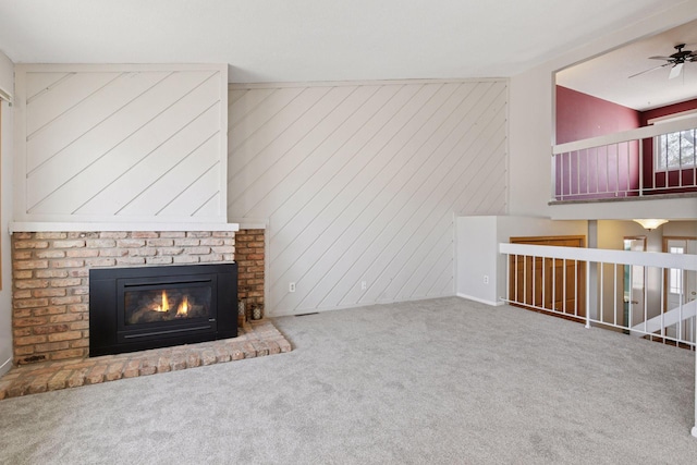 unfurnished living room featuring a fireplace, carpet floors, and ceiling fan