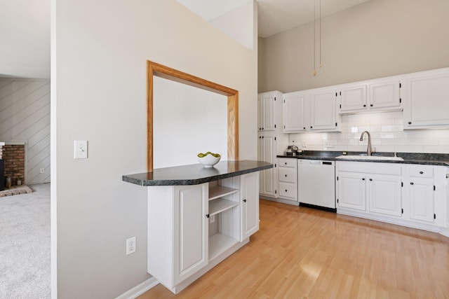 kitchen featuring a sink, open shelves, dark countertops, white cabinets, and dishwasher