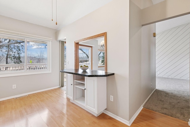 interior space featuring baseboards, light wood-type flooring, and a wealth of natural light