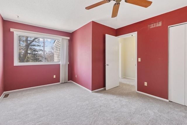 unfurnished bedroom featuring visible vents, ceiling fan, baseboards, and carpet