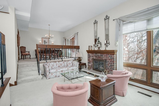 carpeted living area featuring visible vents, a brick fireplace, and an inviting chandelier