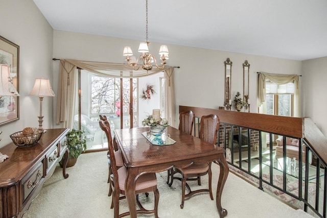 carpeted dining area featuring a healthy amount of sunlight and a chandelier