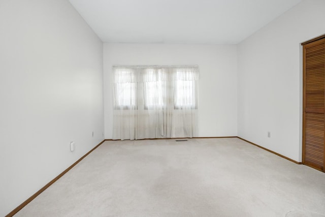 unfurnished room with carpet flooring and baseboards