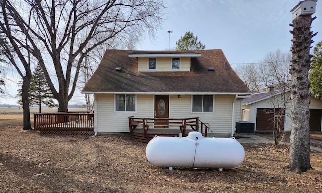 rear view of house with a shingled roof, an outdoor structure, central AC, and a wooden deck