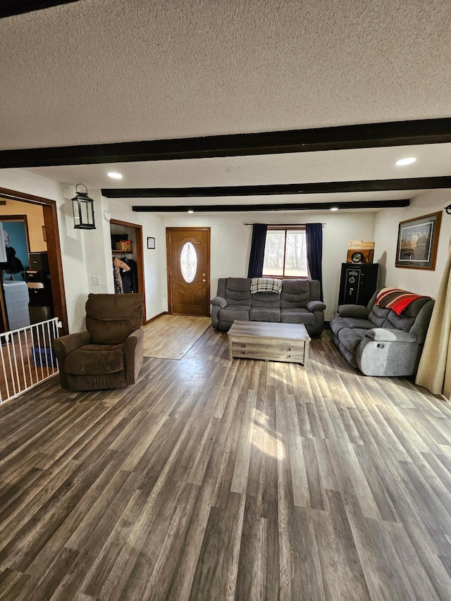 living room featuring beamed ceiling, a textured ceiling, and wood finished floors