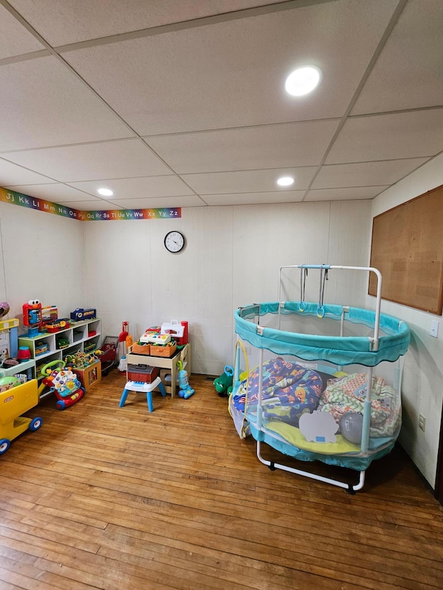 recreation room featuring hardwood / wood-style flooring, recessed lighting, and a drop ceiling