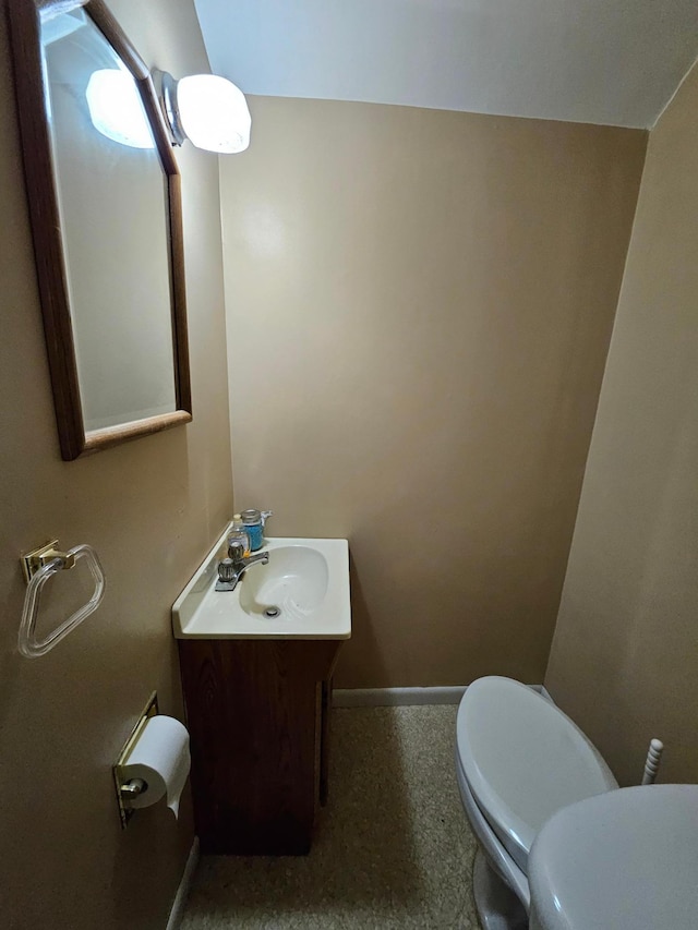 bathroom featuring vanity, toilet, and baseboards