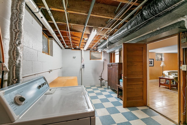 clothes washing area with washer / dryer, tile patterned floors, and laundry area