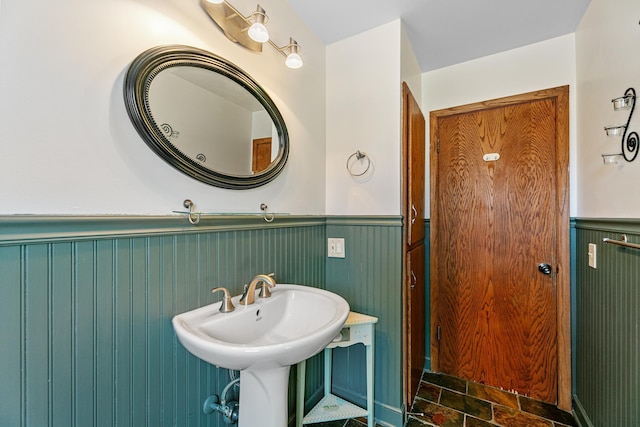 bathroom featuring a sink and a wainscoted wall