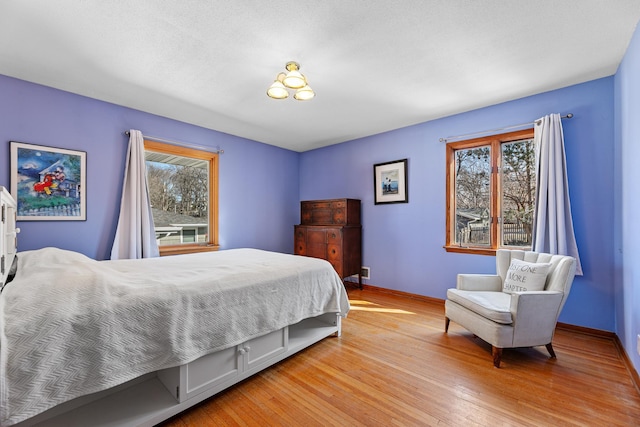 bedroom with light wood-style flooring and baseboards