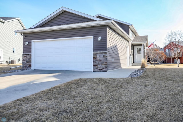 view of front facade featuring stone siding, driveway, a front yard, and a garage