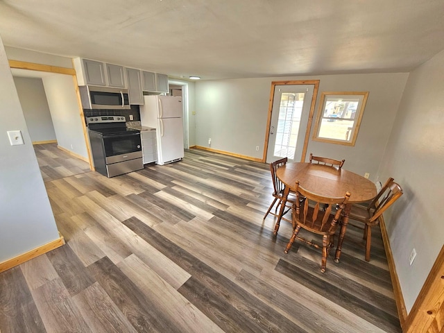 dining area with baseboards and wood finished floors