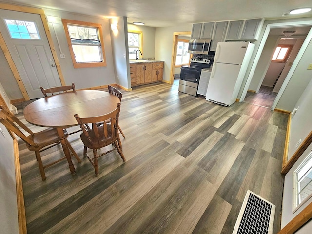 dining room with visible vents, light wood-type flooring, and baseboards