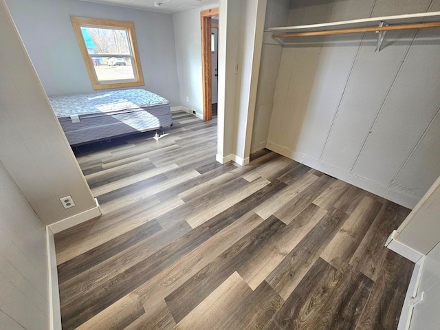 unfurnished bedroom featuring a closet, baseboards, and wood finished floors