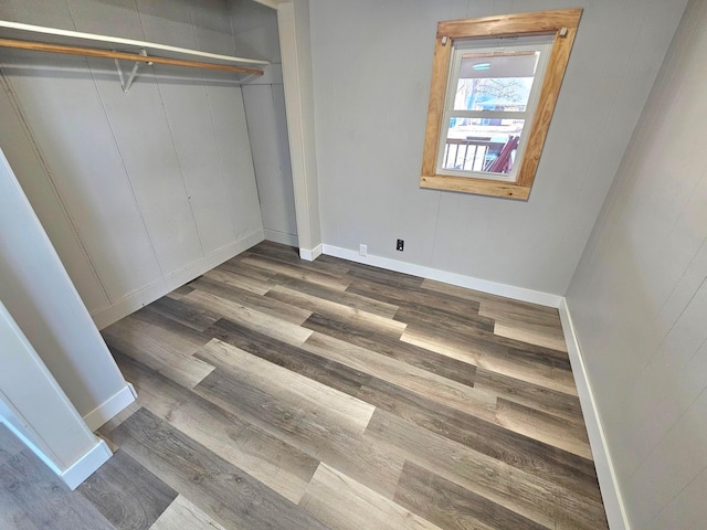 unfurnished bedroom with a closet, baseboards, and wood finished floors