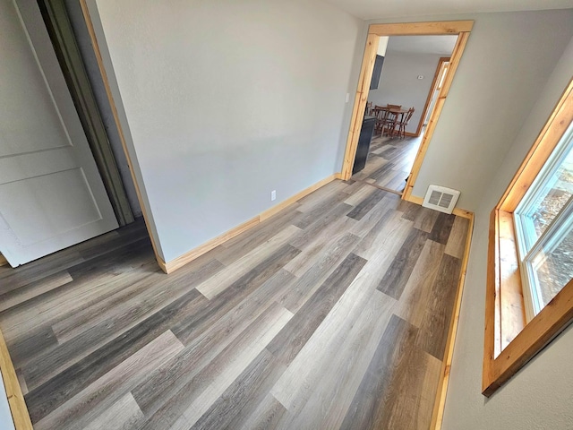 interior space with wood finished floors, visible vents, and baseboards