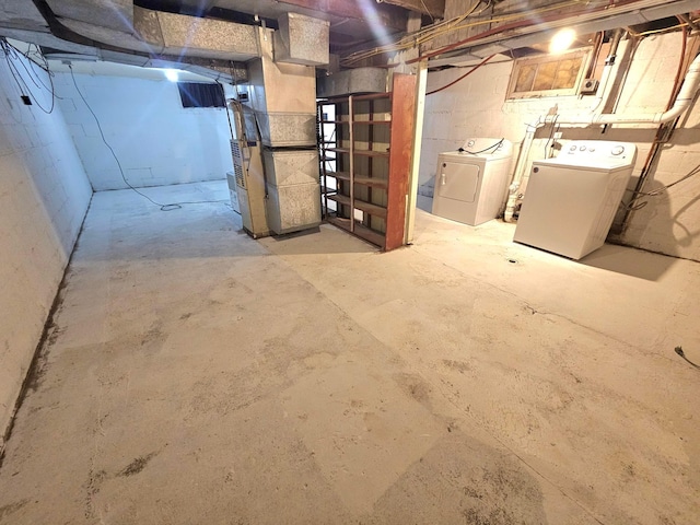 unfinished basement featuring washing machine and clothes dryer and heating unit