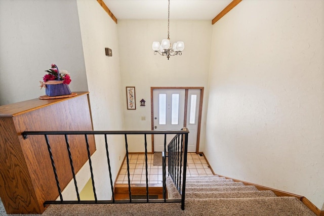 staircase featuring tile patterned floors, baseboards, and a notable chandelier