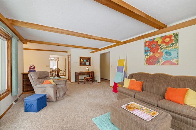 living area featuring beamed ceiling, carpet, visible vents, and a textured ceiling