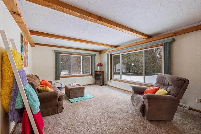 carpeted living room featuring beamed ceiling, baseboards, visible vents, and a textured ceiling