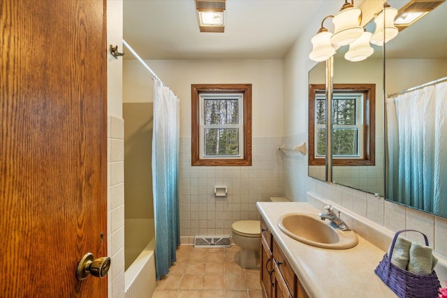 full bathroom featuring tile patterned floors, toilet, a healthy amount of sunlight, and vanity