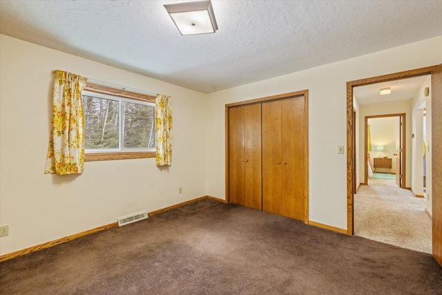 unfurnished bedroom with visible vents, baseboards, carpet floors, a closet, and a textured ceiling