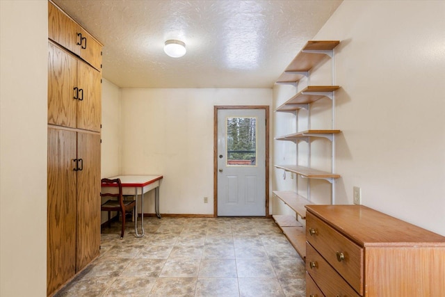 interior space with baseboards and a textured ceiling