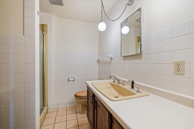 full bathroom featuring tile patterned floors, visible vents, toilet, tile walls, and a shower stall