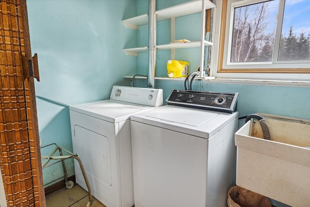 clothes washing area with a sink, laundry area, and washing machine and clothes dryer