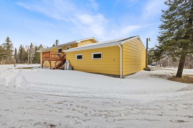 snow covered property featuring stairway and a wooden deck